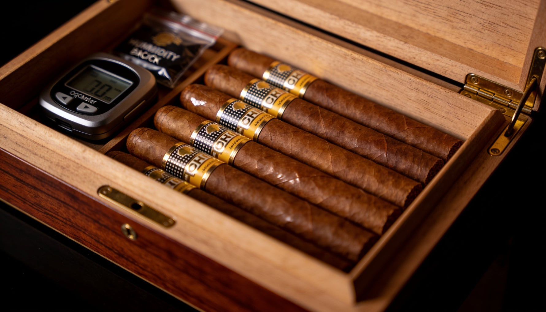Premium cigars aging inside an open wooden humidor with a humidity pack, showing how to age cigars